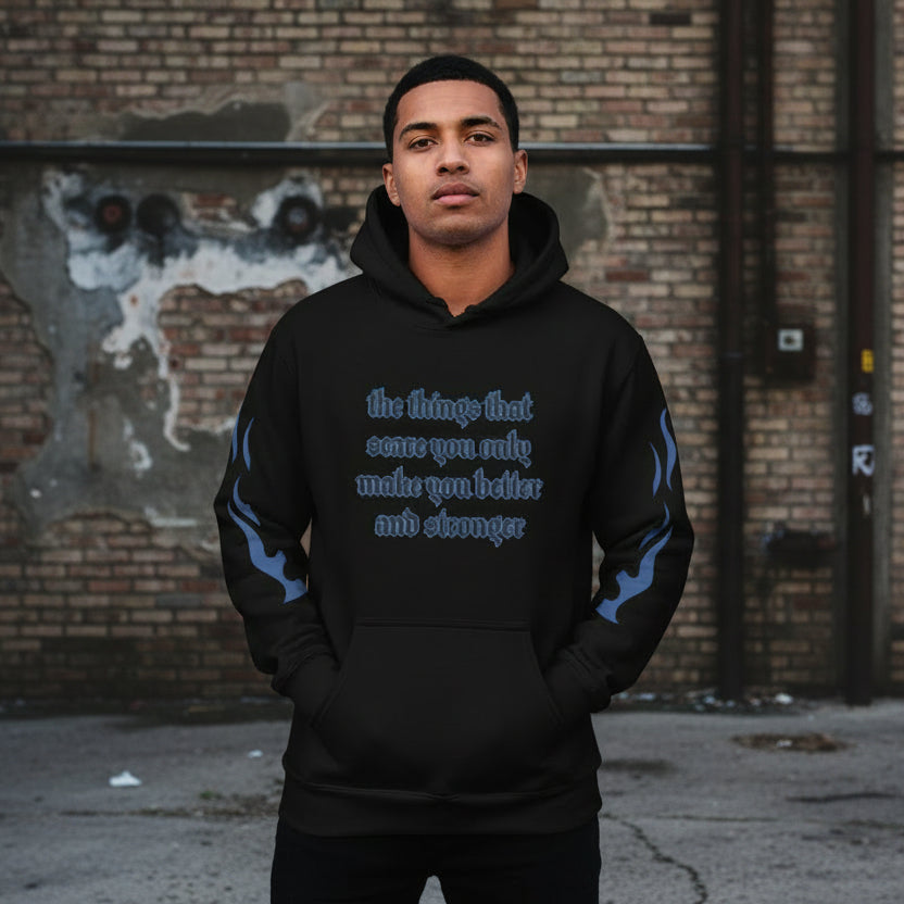 Oversized streetwear hoodie with motivational quote on a model against an urban background.