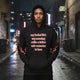 Urban hoodie oversized streetwear model wearing bucket list hoodie in urban setting with city lights.