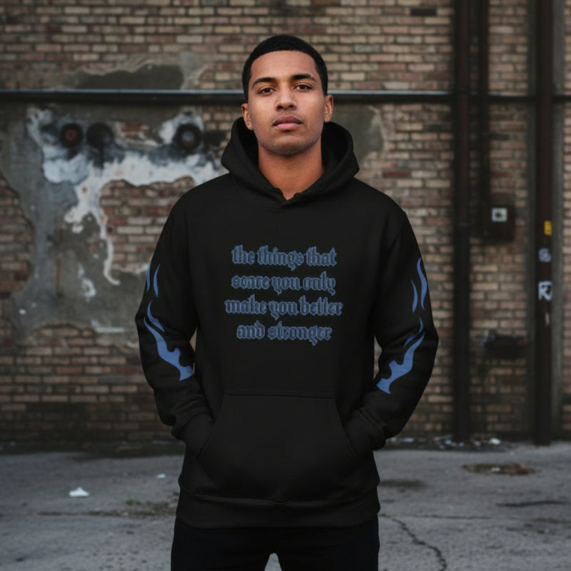 Oversized streetwear hoodie with motivational quote on a model against an urban background.