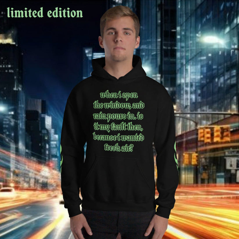 Oversized streetwear hoodie in black featuring green text design, limited edition, capturing a rainy city vibe.